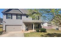 Charming two-story home with gray siding, black shutters, covered front porch, and attached two-car garage at 577 Joneus Dr, Mcdonough, GA 30252