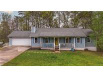 Charming single Gathering home with blue siding, front porch, and attached two-car garage at 1074 Whooping Creek Rd, Carrollton, GA 30116