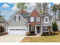 Charming two-story home with brick accents, gray siding, and a well-manicured front yard at 4015 Embassy Way, Lilburn, GA 30047