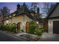 Charming exterior view showcasing the home's unique architecture and landscaped front yard at 23 Paces West Dr, Atlanta, GA 30327