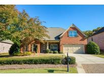 Charming single-story brick home featuring a manicured lawn, two-car garage, and well-maintained landscaping at 4540 Brighton View Trl, Cumming, GA 30040