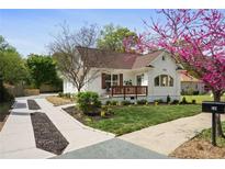 Charming white brick home with a well-manicured lawn and beautiful landscaping, including a mature flowering tree at 102 Rockyford Ne Rd, Atlanta, GA 30317
