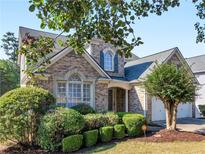Charming two-story brick home featuring a well-manicured lawn and a two-car garage at 152 Vinings Lake Ct, Mableton, GA 30126