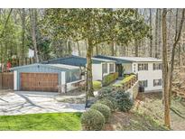 Charming two-story home with a two-car garage, inviting curb appeal, and a well-manicured front yard at 2650 Ridge Valley Nw Rd, Atlanta, GA 30327