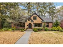 Charming home featuring a unique stone facade, a well-manicured lawn, and mature trees providing ample shade at 103 Dartmouth Ave, Avondale Estates, GA 30002