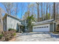Charming two-story home with a two car garage and landscaped front yard at 7127 Riverside Dr, Atlanta, GA 30328