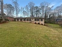 Charming single-story home featuring a well-maintained lawn and classic brick facade at 724 Dukehart Ct, Stone Mountain, GA 30083