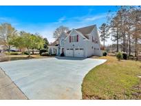 Charming two-story home with a spacious driveway, attached two-car garage, and professionally landscaped front yard at 2445 Ridgelake Dr, Villa Rica, GA 30180