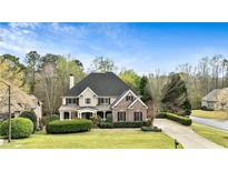 Charming brick and siding home with manicured lawn and mature trees, perfect for suburban living at 500 Poplar Creek Xing, Canton, GA 30114