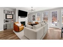 Bright living room featuring a fireplace, and plush white sectional with outdoor access at 234 Retreat Ln, Canton, GA 30114