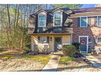 Charming townhome featuring a well-maintained lawn and inviting rocking chairs on the front porch at 241 Quail Run, Roswell, GA 30076