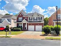 Charming two-story brick home with a well-manicured lawn and two-car garage at 2921 Royston Dr, Duluth, GA 30097