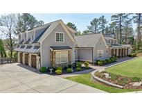 Beautiful two-story home with a three car garage, stone accents, and well manicured landscaping at 3680 Sewell Mill Rd, Marietta, GA 30062