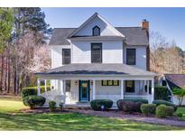 Charming two-story white home with a welcoming front porch, perfect for relaxing and enjoying the outdoors at 1768 Hood Rd, Dacula, GA 30019