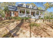 Charming two-story brick home with a welcoming front porch and landscaped front yard at 121 Rising Star Rd, Fayetteville, GA 30215