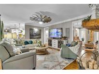 Bright living room featuring neutral furniture, area rug, and unique windmill ceiling fan at 121 Rising Star Rd, Fayetteville, GA 30215