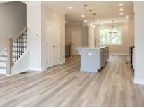 Open-concept living space featuring hardwood floors, staircase, and a modern kitchen island at 1991 Deco Dr, Kennesaw, GA 30144