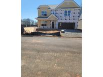 Two story home featuring a two car garage and unfinished construction on a sunny day at 1079 Georgian Point Dr, Lawrenceville, GA 30045