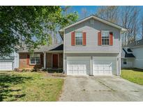 Charming two-story home with brick and siding exterior and a two-car garage at 7324 Drake Ave, Lithonia, GA 30058