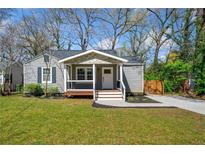 Charming one-story home boasts gray siding, a welcoming front porch, and a well-manicured lawn at 1947 Maywood Nw Pl, Atlanta, GA 30318