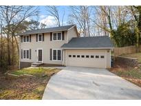 Charming two-story home with tan siding, dark shutters, and an attached two-car garage at 3569 Vinyard Way, Lawrenceville, GA 30044