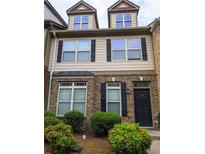 Two story townhome with brick and siding, black shutters, and a well-maintained front yard at 540 Ridge View Xing, Woodstock, GA 30188