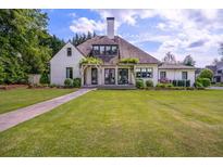 Charming home with lush landscaping, a stone walkway, and an inviting covered porch with pergola at 406 Whitmore Nw Dr, Atlanta, GA 30305