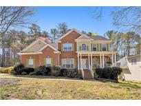 Charming two-story brick home with a welcoming front porch and well-manicured landscaping at 4630 Smokestone Dr, Douglasville, GA 30135