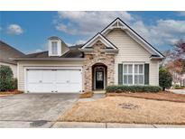 Charming one-story home with stone accents, attached two-car garage, and manicured lawn at 6245 Milton Dr, Cumming, GA 30041