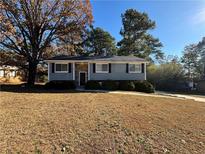 Charming single-story home with a stone accent entry, complemented by mature trees and a well-maintained lawn at 2326 Union Grove Ct, Lithonia, GA 30058