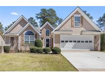 Charming home with a well-manicured lawn, a two-car garage, and a stone-accented entrance at 407 Black Fox Dr, Locust Grove, GA 30248