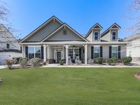 Charming home featuring a well-manicured lawn, inviting front porch, and eye-catching architectural details at 378 Carmichael Cir, Canton, GA 30115