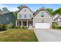 Charming two-story home with a well-maintained lawn and a welcoming front porch and attached two car garage at 557 Winder Trl, Canton, GA 30114