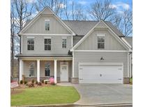Charming two-story home featuring a welcoming porch and an attached two-car garage at 557 Winder Trl, Canton, GA 30114