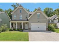 Charming two-story home with a well-manicured lawn and a welcoming covered front porch at 557 Winder Trl, Canton, GA 30114