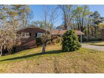Charming one-story brick home with a well-maintained lawn and mature trees provides nice curb appeal at 761 Caron Nw Cir, Atlanta, GA 30318