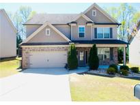 Charming two-story home featuring stone accents, well-manicured lawn, and a two-car garage at 1980 Beyers Landing Dr, Buford, GA 30519