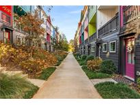 Colorful townhomes line a walkway with manicured landscaping and vibrant curb appeal at 140 Color Cir, Atlanta, GA 30317