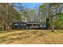 Charming single-story home with well-maintained lawn, trees, and classic exterior details at 460 Stockwood Dr, Woodstock, GA 30188