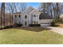 Charming two-story home with a well-maintained lawn and attached two car garage at 400 Surveyors Pt, Suwanee, GA 30024