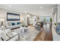 Bright, open-concept living room with modern furnishings and hardwood floors connects to a spacious gourmet kitchen at 1165 Millennium Park Rd, Decatur, GA 30033