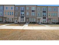 Charming townhomes in a row featuring neutral-colored brick and siding with manicured lawns and inviting entrances at 3323 Owl Creek Pkwy, Acworth, GA 30102