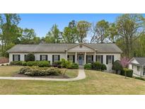 Charming single-story home with manicured lawn, mature trees, and a welcoming front porch at 1724 Ridge Valley Nw Ct, Atlanta, GA 30327