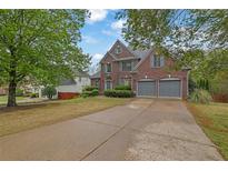 Charming two-story brick home with a well-manicured lawn and a spacious driveway at 5355 Avonshire Ln, Cumming, GA 30040