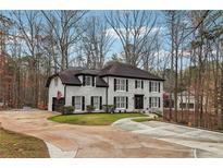 Stately two-story home with brick exterior, black shutters and a wide driveway at 950 Ivy St, Cumming, GA 30041