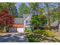Charming two-story home featuring a brick and gray facade with an attached two-car garage at 3107 Sandhurst Dr, Woodstock, GA 30189