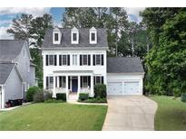 Charming two-story home featuring a well-manicured lawn, symmetrical design and an attached two car garage at 6335 Hampton Creek Dr, Cumming, GA 30041