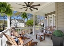 Inviting covered porch with wood furniture and ceiling fan, perfect for relaxing and enjoying the neighborhood views at 235 Chicopee Ne Dr, Marietta, GA 30060