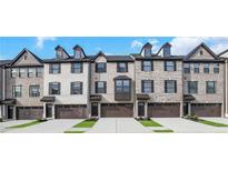 Charming brick townhomes feature symmetrical windows, private garage, and inviting curb appeal at , Lawrenceville, GA 30046