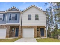 Two-story townhome boasts brick accents, single car garage, and neutral color palette at 7005 Livia Pt, Riverdale, GA 30296